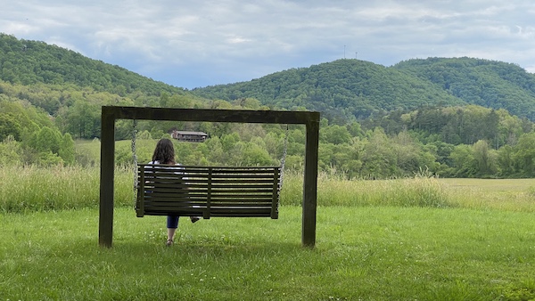 reading on a swing in the mountains